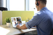 © ty - Businessman in headphones talking to her colleagues in video conference. Business team working from home using laptop, discussing financial report of their company.
