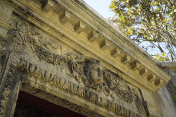 Canvas Print - Low angle shot of an ancient carving on top of entrance stone arch