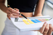 © Natalia - Close-up picture of paper sheet with colorful chart, held in hands of young businesswoman, Office worker getting ready for presentation.