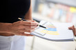 © Natalia - Close-up picture of paper sheet with colorful chart, held in hands of young businesswoman, Office worker getting ready for presentation.
