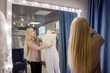 © Ulia Koltyrina - hostess of the wedding salon looks at the wedding dress. Small business,