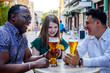 © Andrej - Multiracial group of friends drinking and toasting at street terrace of the cafe. Friendship concept with young multi ethnic people enjoying time together.