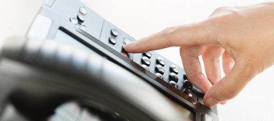 business and communications. Using voip phone in the office, close up of hand of an office staff member. Conference, contact us or message banner. IP telephony, Telemarketing. Help desk or call center