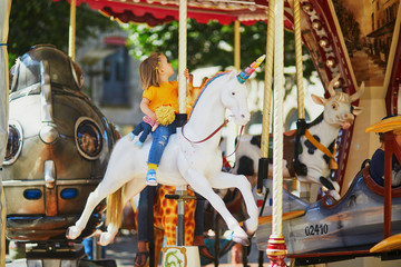 Wall Mural - Toddler having fun on vintage French merry-go-round in Paris