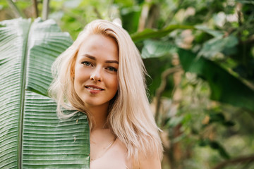 Woman in swimsuit on tropical plants background