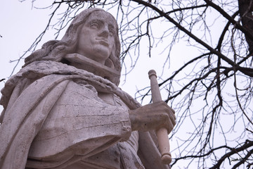 Wall Mural - Low angle shot of a stone statue on a white sky background