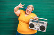 © DisobeyArt - Happy plus size overweight woman dancing and listening rock music with vintage boombox - Emancipation, curvy people and confident concept - Focus on face