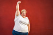 © DisobeyArt - Happy plus-size woman celebrating for female power - Curvy overweight lady dancing with red background - Emancipation and confident concept - Focus on face
