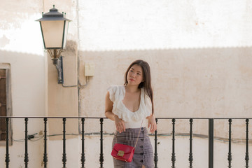 lifestyle portrait of young attractive and beautiful Asian Korean woman outdoors at urban balcony in Spain enjoying summer holidays travel happy and carefree