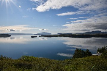 Canvas Print - Islands spiegelglatte Seen mit Bergen im Hintergrund und blauem Himmel mit Wolken