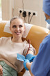 © AnnaStills - Young woman lying on couch and donating blood while smiling to nurse