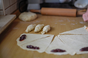 Poster - Closeup shot of a person making pastries and rolling dough with filling