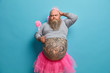 © wayhome.studio  - Fathers day holiday. Serious funny dad with big belly, wears princess outfit, holds magic wand, receieves congratulations from children, isolated over blue background. Playful male fairy indoor