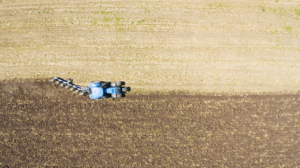 Poster - Aerial top view of a tractor on an industrial field