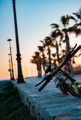 Poster - Vertical shot of a bicycle parked on the street with the sunset in the background