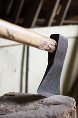 Wall Mural - Closeup vertical shot of a chopping ax with a white plank on the background