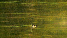 Minimalistic Overhead Shot Of A Combine Mowing A Grass Field