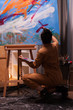 © DC Studio - Back view of artist in art studio working on impressionism painting. Modern artwork paint on canvas, creative, contemporary and successful fine art artist drawing masterpiece