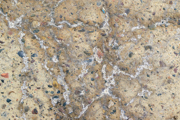 Concrete wall for the backdrop. White salty  excretion. Multi-colored stones.