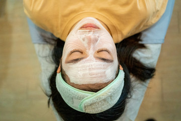 Young Asian female teenager getting her acne and facial treatment