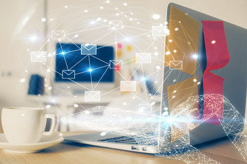 Desktop computer background in office and flying envelops hologram drawing. Double exposure. Electronic mail concept.