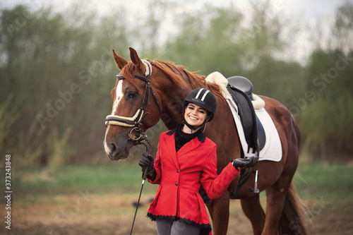 Fotomural Portrait Jockey woman rider with brown horse, concept advertising equestrian clu