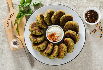 Wall Mural - delicious vegan eggplant cutlets with yogurt and hot pepper sauce, cuisine of the Calabria region in Italy on a linen tablecloth on the table