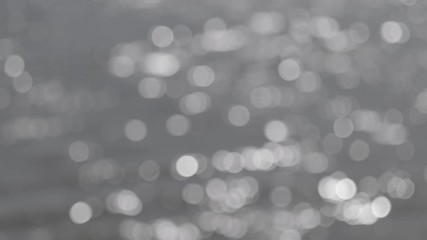 Wall Mural - bokeh sun glare reflected in water surface. abstract ripples, sun glares, circles on waves water. ro
