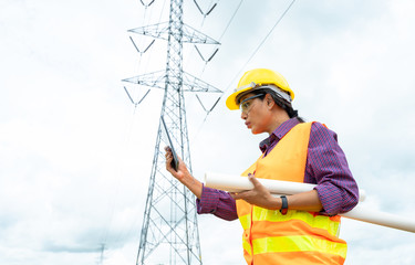 Fototapete - Electrical engineer use tablet working check high voltage pole Power Transmission.
