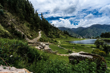 Wall Mural - Beautiful scenery of a green landscape with a river and greenery