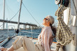 © Artem Varnitsin - Side view of mature woman sitting on yacht and enjoying sunny day. Senior woman relaxing on private boat.