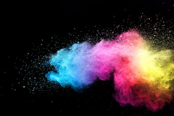Wall Mural - explosion of colored powder isolated on black background.