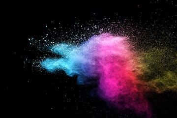 Wall Mural - explosion of colored powder isolated on black background.