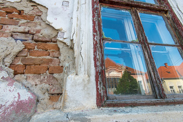 Old weathered wood window and wall on an old abandoned residential house.