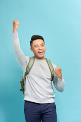 Wall Mural - Young man with a backpack isolated on blue background with surprise facial expression