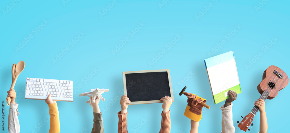 Children are holding books, toys, and a keyboard. Educational concept - obrazy, fototapety, plakaty 