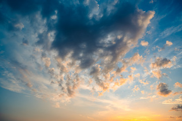 Wall Mural - Beautiful summer sky full of clouds at sunset at golden hour. Interesting warm colors on the horizon.