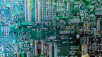 Green background of PC computer motherboard printed circuit Board. Electronic computer system Board, digital chip, transistor, chip. Inner part close-up. Technological background, digital world.