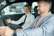 © pressmaster - Happy mature man sitting in new car and holding by steer during test drive