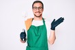 © Krakenimages.com - Young handsome man wearing apron holding toilet brush celebrating victory with happy smile and winner expression with raised hands