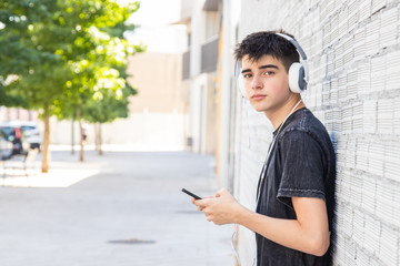 Poster - male teenager with headphones and phone on the street