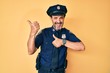 © Krakenimages.com - Middle age hispanic man wearing police uniform pointing to the back behind with hand and thumbs up, smiling confident