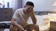 © PRPicturesProduction - portrait of man sitting at bedside touching forehead is suffering from insomnia. asian male staying awake until daybreak is painful. sleep disorder and health problem concept.
