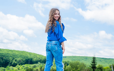 Hip and stylish. hipster kid. happy childrens day. happy childhood. smiling child with curly hairstyle. hair beauty and care. kid fashion style. teenage girl on sky background outdoor