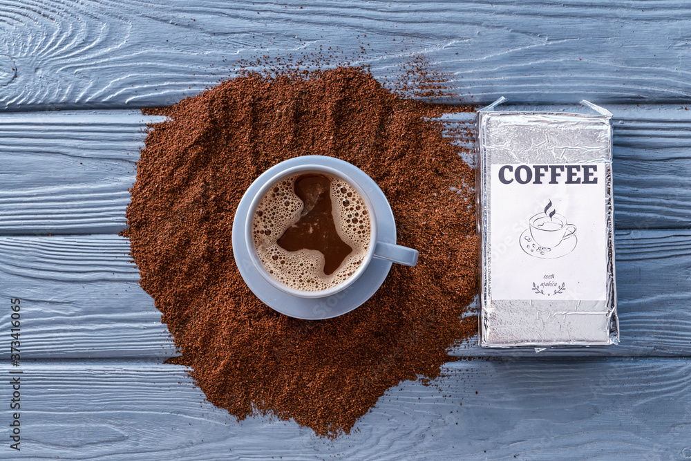 Cup of coffee and powder on table