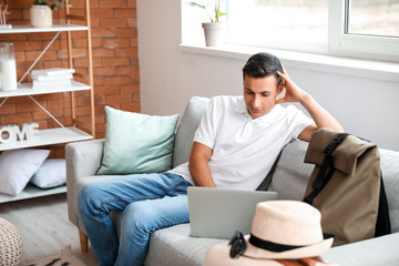 Wall Mural - Man with laptop booking tickets online at home