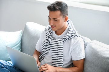 Wall Mural - Man with laptop booking tickets online at home