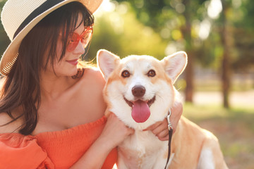 Wall Mural - Woman with cute corgi dog walking outdoors