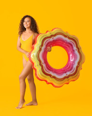 Sticker - Beautiful young African-American woman with inflatable ring on color background