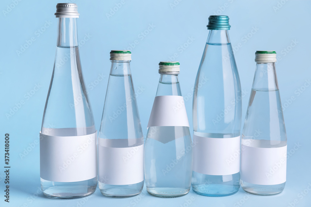 Bottles of clean water on color background